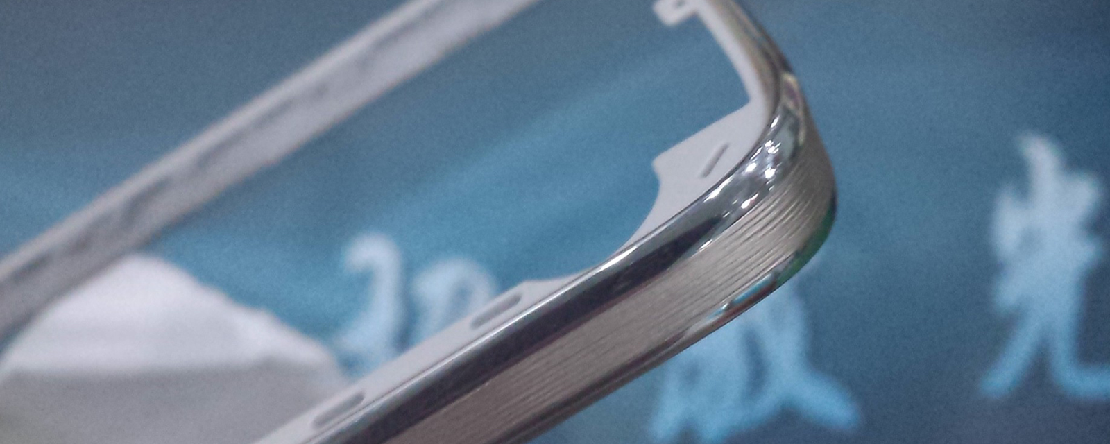 Polished metallic component edge with fine laser-textured grooves, indicative of precision industrial laser processing.